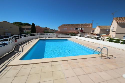 une piscine sur le toit d'une maison dans l'établissement Maison T3 cabine 4 couchages, terrasse cloturée, résidence Sun village avec piscine commune, 300m de la plage à PORTIRAGNES -LRSUNP5, à Portiragnes