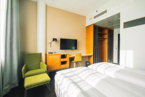 a hotel room with a bed and a desk and a tv at Comfort Hotel Sello in Espoo