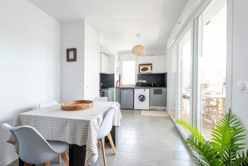 une cuisine et une salle à manger avec une table et des chaises dans l'établissement Le Logis du Bassin - Meublé 3 étoiles, à Arcachon