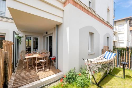 une terrasse en bois avec une table et des chaises sur une maison dans l'établissement Le Logis du Bassin - Meublé 3 étoiles, à Arcachon