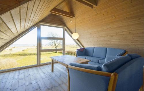 a living room with a blue couch and a table at Holiday Home Glombak in Øsløs