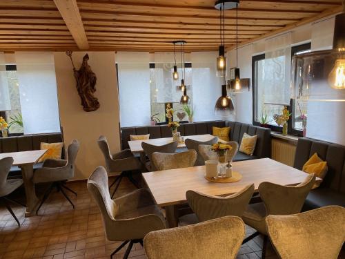 a restaurant with tables and chairs in a room at Landhaus Am Forst in Bad Alexandersbad