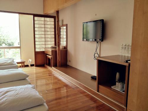 a living room with a tv and a bed at 復興青年活動中心 復興比雅山會館 in Fuxing