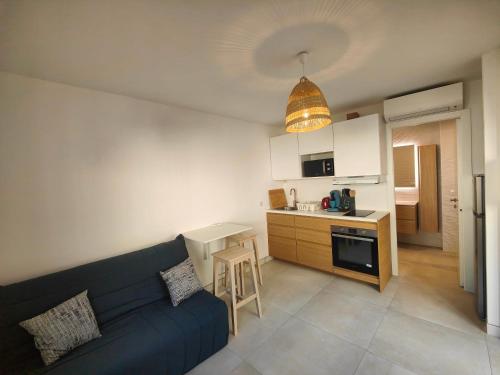 un salon avec un canapé bleu et une cuisine dans l'établissement studio la mimosette, à Cannes