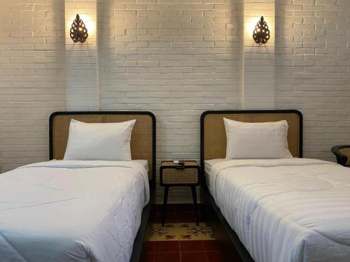 two beds sitting next to each other in a room at The Satu Stay Damai in Kejayan