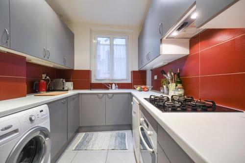 Il comprend une cuisine équipée d'une cuisinière et d'un lave-linge/sèche-linge. dans l'établissement GuestReady - Charm an Comfort in Épinettes, à Paris