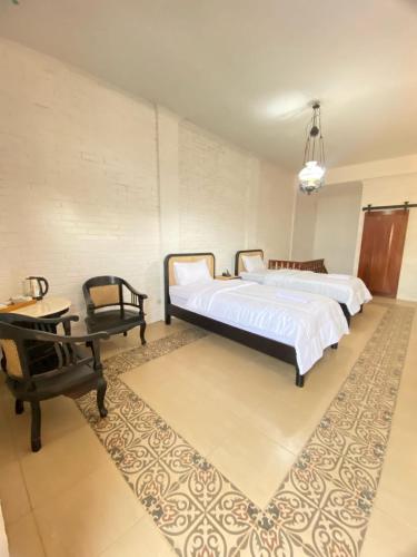 a bedroom with a bed and a table and a chair at The Satu Stay Damai in Kejayan