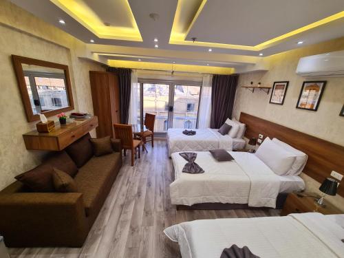a hotel room with two beds and a couch at tourist hotel cairo downtown in Cairo