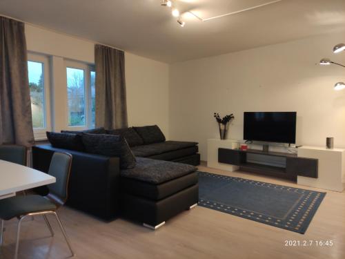 a living room with a couch and a tv at Gemütliche Wohnung an der Schweizer Grenze in Gottmadingen