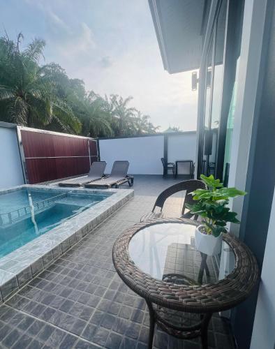 a balcony with a pool and a table and chairs at Vina Villa At Krabi in Ao Nang 