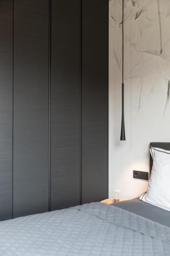 a bedroom with a white bed and a black wall at GOING TRIPLE A apartments EAST in Going