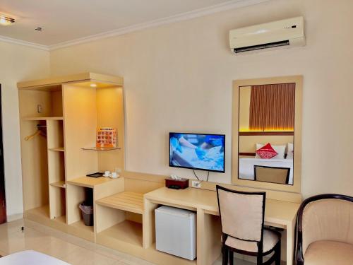 a room with a desk with a computer and a bed at Hotel Cepu Indah 1 in Cepu