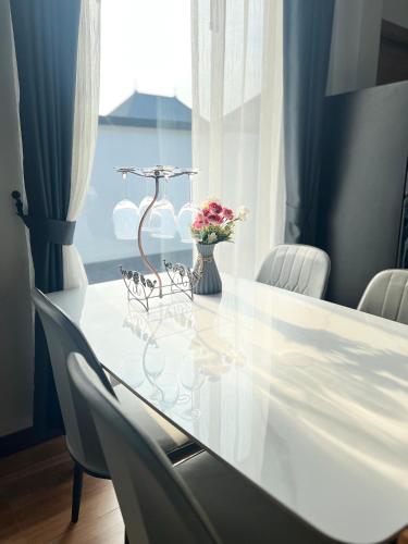 a white table with chairs and a vase with flowers at Vina Villa At Krabi in Ao Nang 