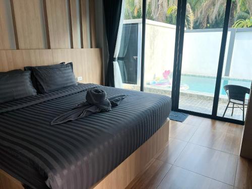 a bed with a hat and a ribbon on it at Vina Villa At Krabi in Ao Nang 