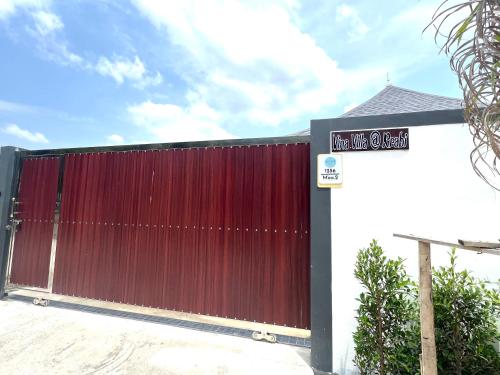 a red gate with a street sign in front of it at Vina Villa At Krabi in Ao Nang 