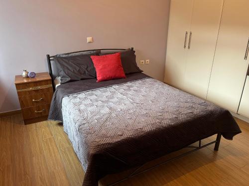 a bedroom with a bed with a red pillow on it at Sunshine 2 in Leonidion