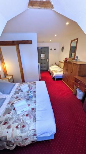 a bedroom with two beds and a red carpet at Le Bataclan in Auron