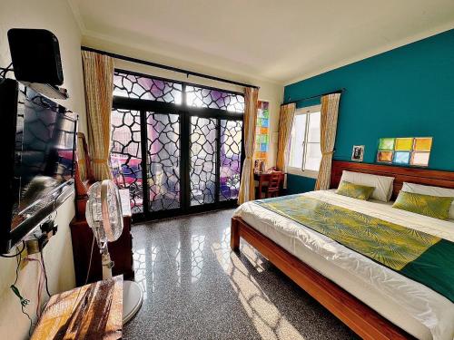 a bedroom with a bed and a stained glass window at Village Hostel in Xiaoliuqiu