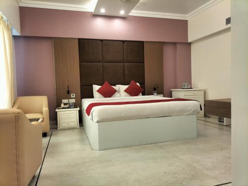 a bedroom with a large bed with red pillows at Zip By Spree Hotels Surabi International Vellore in Vellore