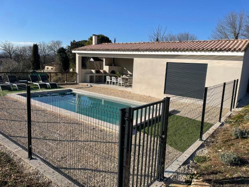 une clôture autour d'une piscine en face d'une maison dans l'établissement Maison contemporaine, à Saint-Privat-de-Champclos