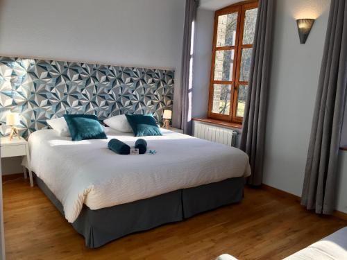 a bedroom with a large bed with blue pillows at Chambres d'hotes au Domaine de Clarat in Lafarre