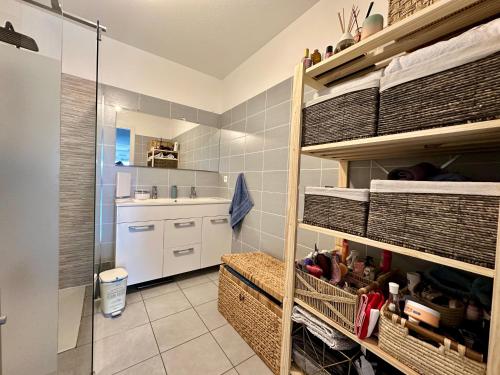 une cuisine avec des armoires blanches et un évier dans l'établissement Appartement Cardellina Jardin & Ville, à Calvi