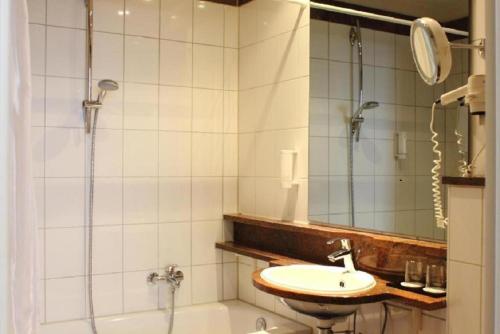 a bathroom with a shower and a sink and a tub at Wyndham Garden Berlin Mitte in Berlin