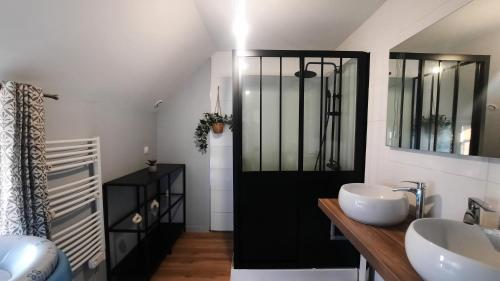 une salle de bain avec deux lavabos et un miroir dans l'établissement Maison de caractère bretonne « L’entre deux », au Vivier-sur-Mer