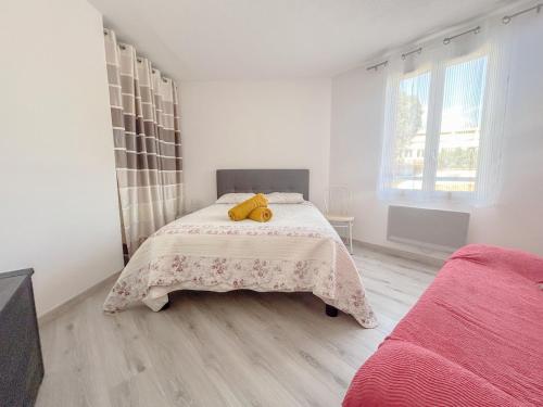 - un ours en peluche assis sur un lit dans une chambre dans l'établissement F2 avec terrasse et parking privé à Fréjus, à Fréjus