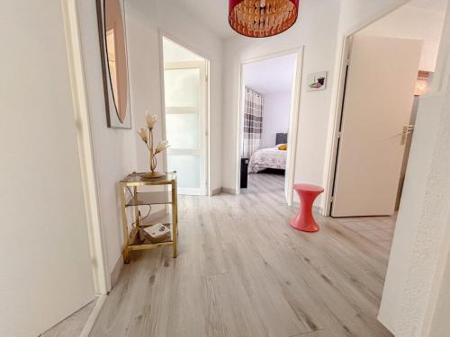 - un salon avec un vase rouge sur du parquet dans l'établissement F2 avec terrasse et parking privé à Fréjus, à Fréjus
