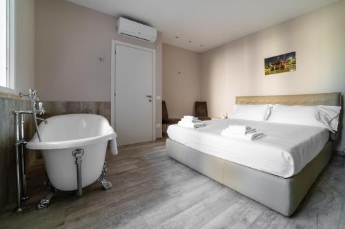 - une chambre avec un lit, une baignoire et un lit avec un lavabo dans l'établissement Wanderlust by MONHOLIDAY, à Monopoli