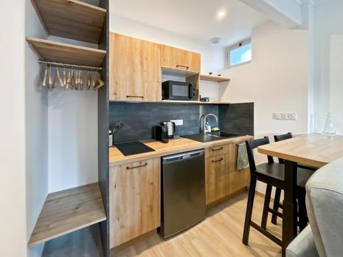 une cuisine avec des placards en bois et une table en bois avec une salle à manger dans l'établissement Studio Douceur Marine, à Criel-sur-Mer