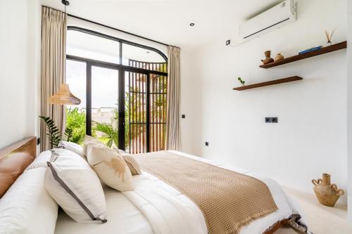 a bedroom with a bed with a large window at Casa Nalani in Kerobokan