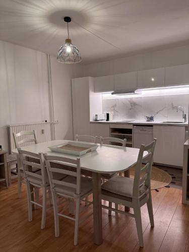 une cuisine avec une table et des chaises dans une pièce dans l'établissement Vacances à Trouville en famille vue mer, à Trouville-sur-Mer