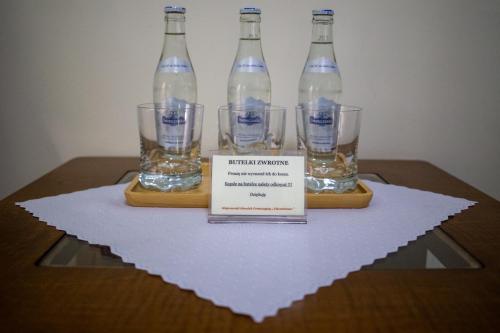 three bottles of water on a table with a sign at Dom rekolekcyjny Vincentinum in Krzeszowice