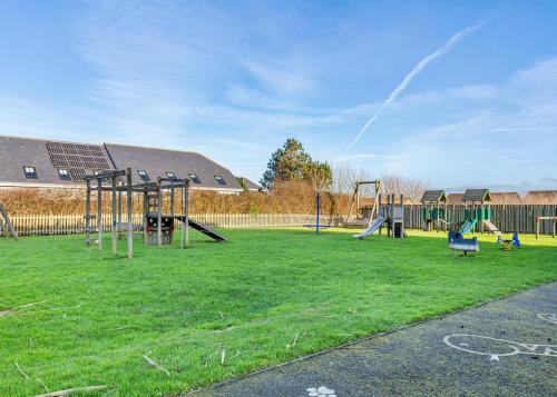 a playground with two swings and a slide at Bay Retreat Villas in Saint Merryn
