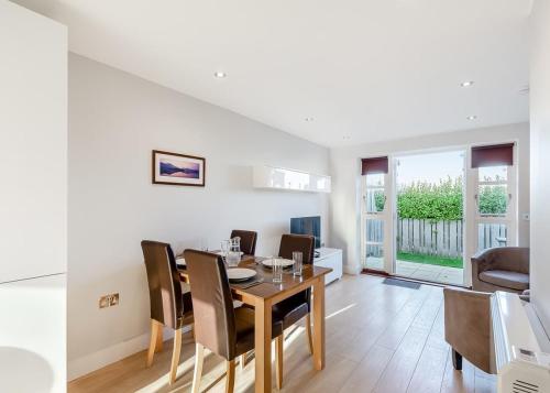 a dining room and living room with a table and chairs at Bay Retreat Villas in Saint Merryn