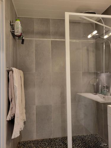 une douche avec une porte vitrée dans une salle de bain dans l'établissement Beau T3 au calme, vue mer imprenable, à Sète