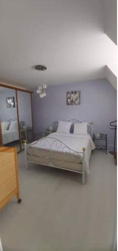 une chambre avec un lit dans une pièce blanche dans l'établissement Maison de caractère bretonne « L’entre deux », au Vivier-sur-Mer