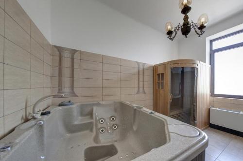 un bagno con ampia vasca e finestra di Hotel Boutique ANEMONA a Craiova