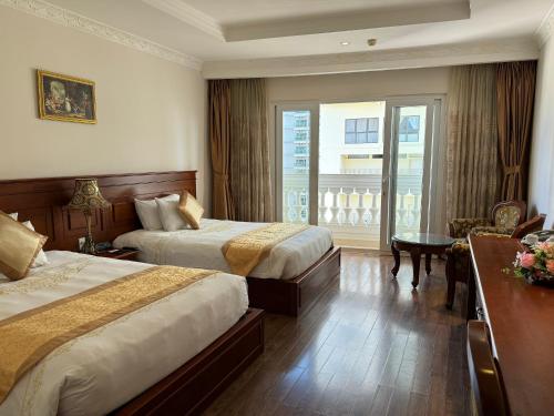 a hotel room with two beds and a balcony at Nha Trang Palace Hotel in Nha Trang