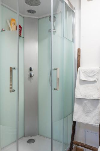 une douche avec une porte vitrée dans une salle de bain dans l'établissement Petit studio au coeur de Caen, à Caen
