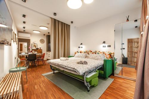 a bedroom with a green bed and a table at SIX IN THE CITY Apartment, LJUBLJANA in Ljubljana