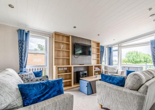 a living room with two couches and a tv at Hanworth Country Park in Potter Hanworth