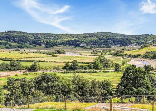 a view of a field with trees and a river at Kippford View Holiday Park in Castle Douglas