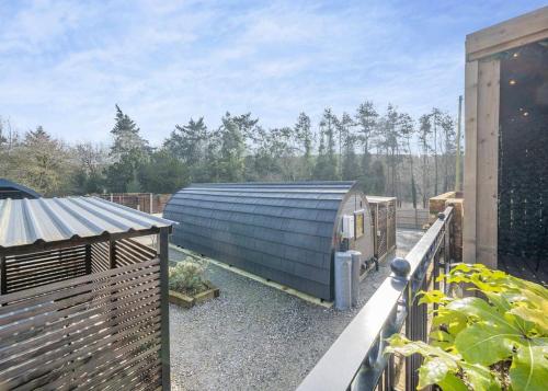 a garden with a blue building on a balcony at Hill Farm Retreat in Wangford