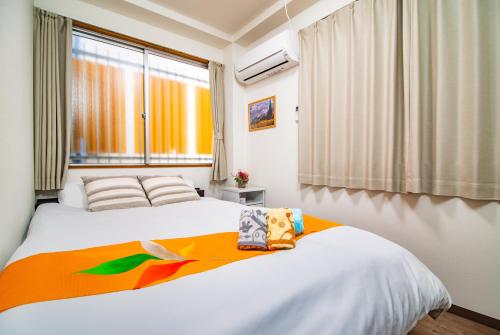 Un dormitorio con una cama y una ventana. en Aozora, en Osaka