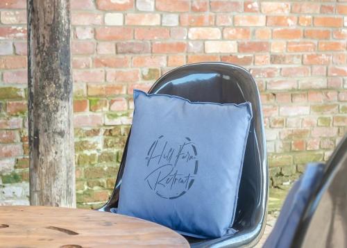 a blue pillow sitting on a chair next to a table at Hill Farm Retreat in Wangford
