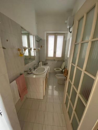 a bathroom with two sinks a toilet and a mirror at Antica dimora Cauto in Pietramelara