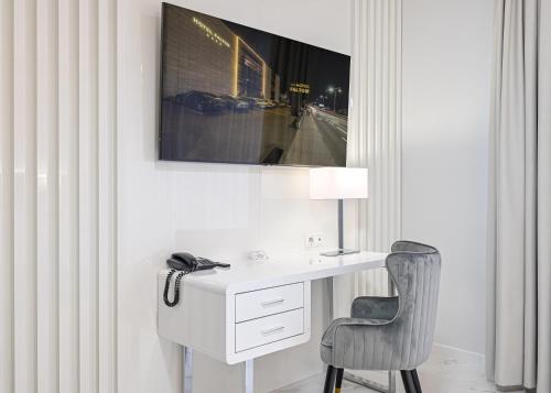 a white desk with a chair and a lamp at Hotel SPA Faltom Gdynia Rumia in Rumia